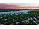Aerial view showcasing the property's proximity to water and surrounding lush greenery, highlighted with yellow arrow at 4791 S Peninsula Dr, Ponce Inlet, FL 32127