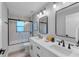 Bright bathroom features double sinks, modern fixtures, and shower-over-tub with sliding glass at 4791 S Peninsula Dr, Ponce Inlet, FL 32127
