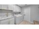 Well-organized laundry room featuring modern washer, dryer, sink, and cabinet storage at 4791 S Peninsula Dr, Ponce Inlet, FL 32127
