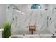 A luxury shower with a wooden bench and dual shower heads, surrounded by sleek marbled tile at 4791 S Peninsula Dr, Ponce Inlet, FL 32127