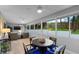 Bright sunroom with a wall of windows and a round dining table for a casual dining at 4791 S Peninsula Dr, Ponce Inlet, FL 32127