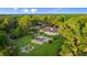 Stunning aerial view of home with pool, pergola, lush landscaping and surrounded by mature trees on a private lot at 4885 State Road 11, De Leon Springs, FL 32130