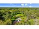 Expansive aerial view showcasing the pool, lush greenery, and secluded location of the property at 4885 State Road 11, De Leon Springs, FL 32130