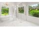 Light-filled bathroom features marble floors, freestanding tub, and glass-enclosed shower at 4885 State Road 11, De Leon Springs, FL 32130