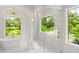 Bright bathroom with large windows, a glass-enclosed shower, and an elegant standalone tub at 4885 State Road 11, De Leon Springs, FL 32130