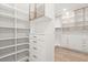 Well-organized closet with white shelving, cabinets, drawers, gold hardware, and wood-look flooring at 4885 State Road 11, De Leon Springs, FL 32130