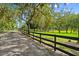 Scenic driveway leading to the property, framed by a classic black fence at 4885 State Road 11, De Leon Springs, FL 32130