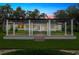 Elegant home featuring a column-lined pergola, manicured lawn, and tasteful landscaping enhances its curb appeal at 4885 State Road 11, De Leon Springs, FL 32130