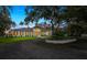 A picturesque, single-story home is framed by mature oak trees and a manicured front lawn at 4885 State Road 11, De Leon Springs, FL 32130