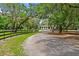 Long gravel driveway leads to a stately home surrounded by manicured lawns and mature trees at 4885 State Road 11, De Leon Springs, FL 32130