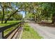 Gravel driveway view leading to home with manicured lawns and mature trees at 4885 State Road 11, De Leon Springs, FL 32130