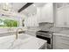 Bright, spacious kitchen featuring marble countertops, white cabinetry, and a professional grade gas range at 4885 State Road 11, De Leon Springs, FL 32130