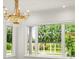 Sunlit living room with scenic views of the landscaped backyard through large windows at 4885 State Road 11, De Leon Springs, FL 32130