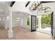 Open-concept living room showcasing hardwood floors, coffered ceilings, and decorative lighting at 4885 State Road 11, De Leon Springs, FL 32130