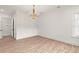 Empty living room with hardwood floors, decorative chandelier, and bright light at 4885 State Road 11, De Leon Springs, FL 32130