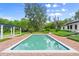 Sparkling rectangular pool nestled in a brick patio, surrounded by greenery, perfect for outdoor relaxation and enjoyment at 4885 State Road 11, De Leon Springs, FL 32130
