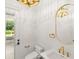 Elegant powder room with custom lighting, gold fixtures, and views of the backyard at 4885 State Road 11, De Leon Springs, FL 32130