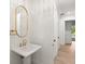 Chic powder room with white pedestal sink, gold accents, and a framed mirror at 4885 State Road 11, De Leon Springs, FL 32130
