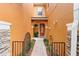 Inviting front entrance with an orange-colored facade, well-kept walkway and decorative gate at 5060 Cypress Branch Pt, Oviedo, FL 32765