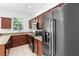 A kitchen featuring granite counters, wood cabinets, black appliances, and stainless steel refrigerator at 5060 Cypress Branch Pt, Oviedo, FL 32765