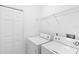 This laundry room is equipped with a washer, dryer, and storage shelves at 5060 Cypress Branch Pt, Oviedo, FL 32765