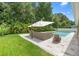 Well-manicured backyard features a spacious patio with comfortable seating and a view of the sparkling pool at 508 Morgan Wood Dr, Deland, FL 32724