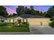 Charming single-story home at twilight, showcasing its inviting curb appeal and convenient three-car garage at 508 Morgan Wood Dr, Deland, FL 32724