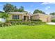 Inviting single-story home featuring lush landscaping, a well-manicured lawn, and a convenient three-car garage at 508 Morgan Wood Dr, Deland, FL 32724
