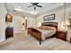 Spacious main bedroom featuring a tray ceiling, ensuite bathroom, and dark wood furniture at 508 Morgan Wood Dr, Deland, FL 32724