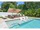 Inviting pool area boasts submerged lounge chairs and comfortable patio seating under a large shade umbrella at 508 Morgan Wood Dr, Deland, FL 32724