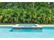 Sparkling pool features a stone-accented hot tub surrounded by lush greenery, offering a private backyard oasis at 508 Morgan Wood Dr, Deland, FL 32724