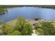 A beautiful aerial showcasing a lakeside house amidst lush greenery and serene lake views at 510 Sandy Bluff Trl, Deland, FL 32724