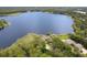 Breathtaking view of a beautiful house adjacent to the serene lake, surrounded by lush vegetation at 510 Sandy Bluff Trl, Deland, FL 32724