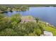 Stunning aerial view of a lakefront home surrounded by lush greenery and tranquil waters at 510 Sandy Bluff Trl, Deland, FL 32724