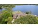 An aerial view of a large home surrounded by lush trees and backing onto a lake at 510 Sandy Bluff Trl, Deland, FL 32724