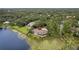 Beautiful lakefront property with a spacious home, dock, and surrounded by mature trees and vegetation at 510 Sandy Bluff Trl, Deland, FL 32724