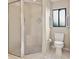 Bathroom featuring a glass-enclosed shower, a toilet, and a window for natural light at 510 Sandy Bluff Trl, Deland, FL 32724