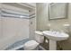 Bathroom featuring blue and white tiling in the shower and floor, and a stylish pedestal sink at 510 Sandy Bluff Trl, Deland, FL 32724