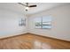 Bright, empty bedroom with light hardwood floors, two windows with nice outdoor view, and a ceiling fan at 510 Sandy Bluff Trl, Deland, FL 32724