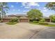 A well-maintained property with lush landscaping and a large driveway leading to multiple garages at 510 Sandy Bluff Trl, Deland, FL 32724