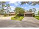 A well-maintained property with lush landscaping and a large driveway leading to multiple garages at 510 Sandy Bluff Trl, Deland, FL 32724