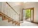 Bright, tiled foyer with a staircase and front door with glass accents at 510 Sandy Bluff Trl, Deland, FL 32724