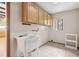 Laundry room features a utility sink, tile floor and storage cabinets at 510 Sandy Bluff Trl, Deland, FL 32724