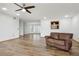 Spacious living room with wood flooring, ceiling fan, and a comfortable brown leather couch at 510 Sandy Bluff Trl, Deland, FL 32724
