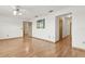 Bright living room with light wood floors, a ceiling fan, and an adjacent hallway at 510 Sandy Bluff Trl, Deland, FL 32724