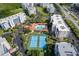 Aerial view of the complex featuring two tennis courts, the community pool, and palm trees at 5300 S Atlantic Ave # 12-401, New Smyrna Beach, FL 32169