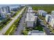 An aerial view of condo buildings, beachfront property, palm trees, and ample parking near a scenic roadway and the ocean at 5300 S Atlantic Ave # 12-401, New Smyrna Beach, FL 32169