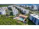Aerial view of condo buildings featuring a pool, lush vegetation, and scenic views of the ocean in a vibrant community at 5300 S Atlantic Ave # 12-401, New Smyrna Beach, FL 32169