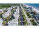 Aerial view featuring condo buildings, a beachfront with tennis courts, palm-lined parking, a roadway, and scenic coastal views at 5300 S Atlantic Ave # 12-401, New Smyrna Beach, FL 32169