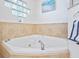 Bathroom featuring a large soaking tub, tile accent wall and tiled floors at 5300 S Atlantic Ave # 12-401, New Smyrna Beach, FL 32169